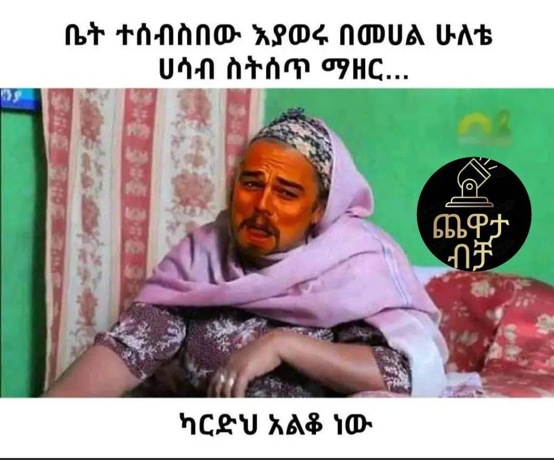 a man in a pink scarf sitting on a couch